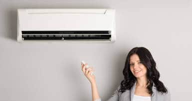 professional-woman-controlling-air-conditioning-unit-with-remote-handset